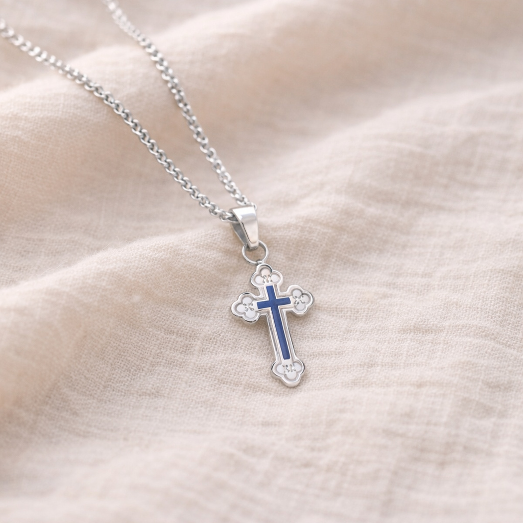 Silver Orthodox cross necklace with blue accents on a beige fabric background Christian faith jewelry