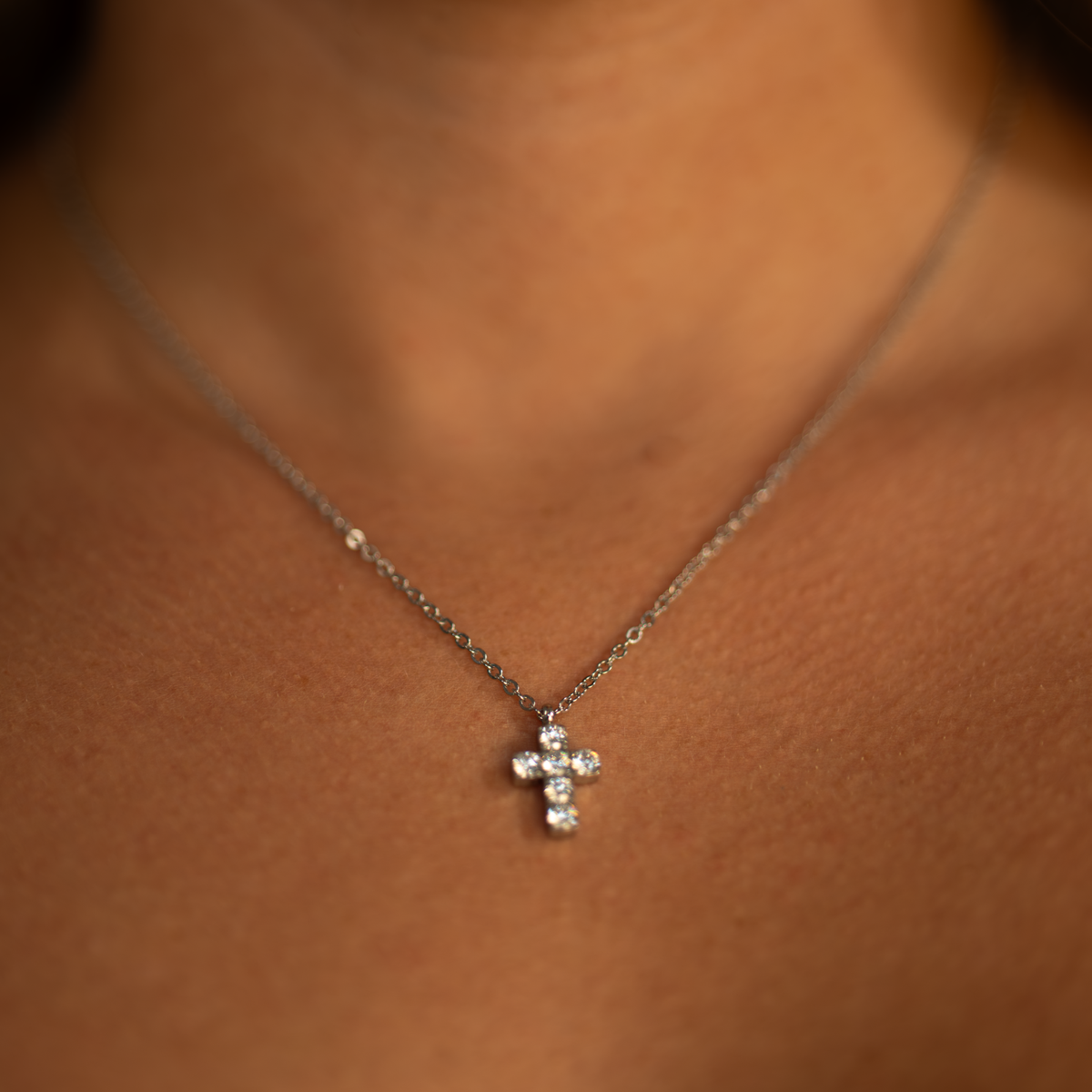 Women wearing small silver cross necklace with CZ stones faith jewelry